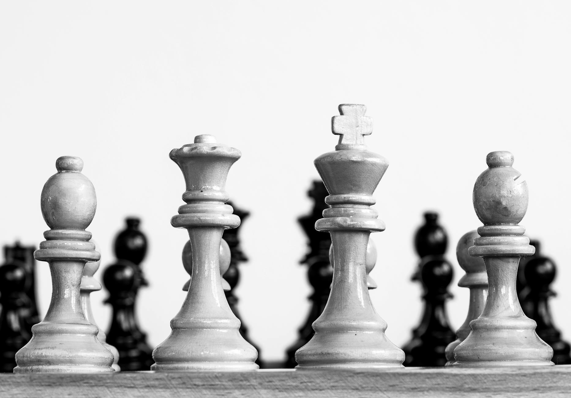 a grayscale photo of chess pieces